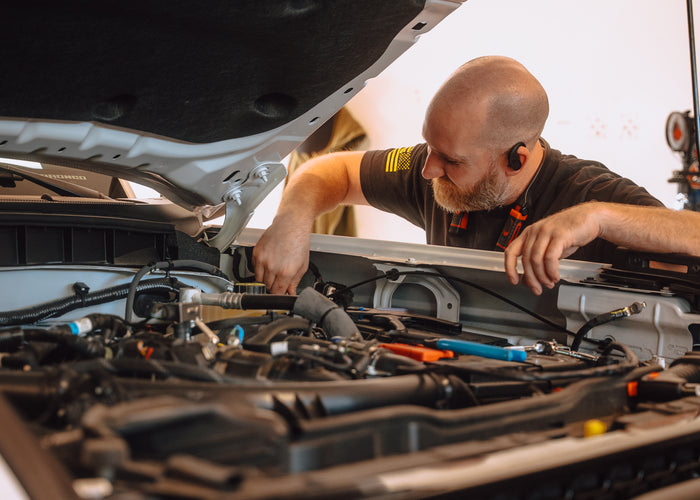 Mule technician checking brake booster in engine bay